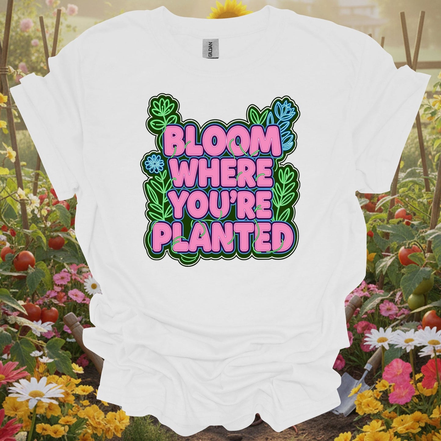 White tee showing bright bloom where you're planted text with plants for gardeners who need the reminder
