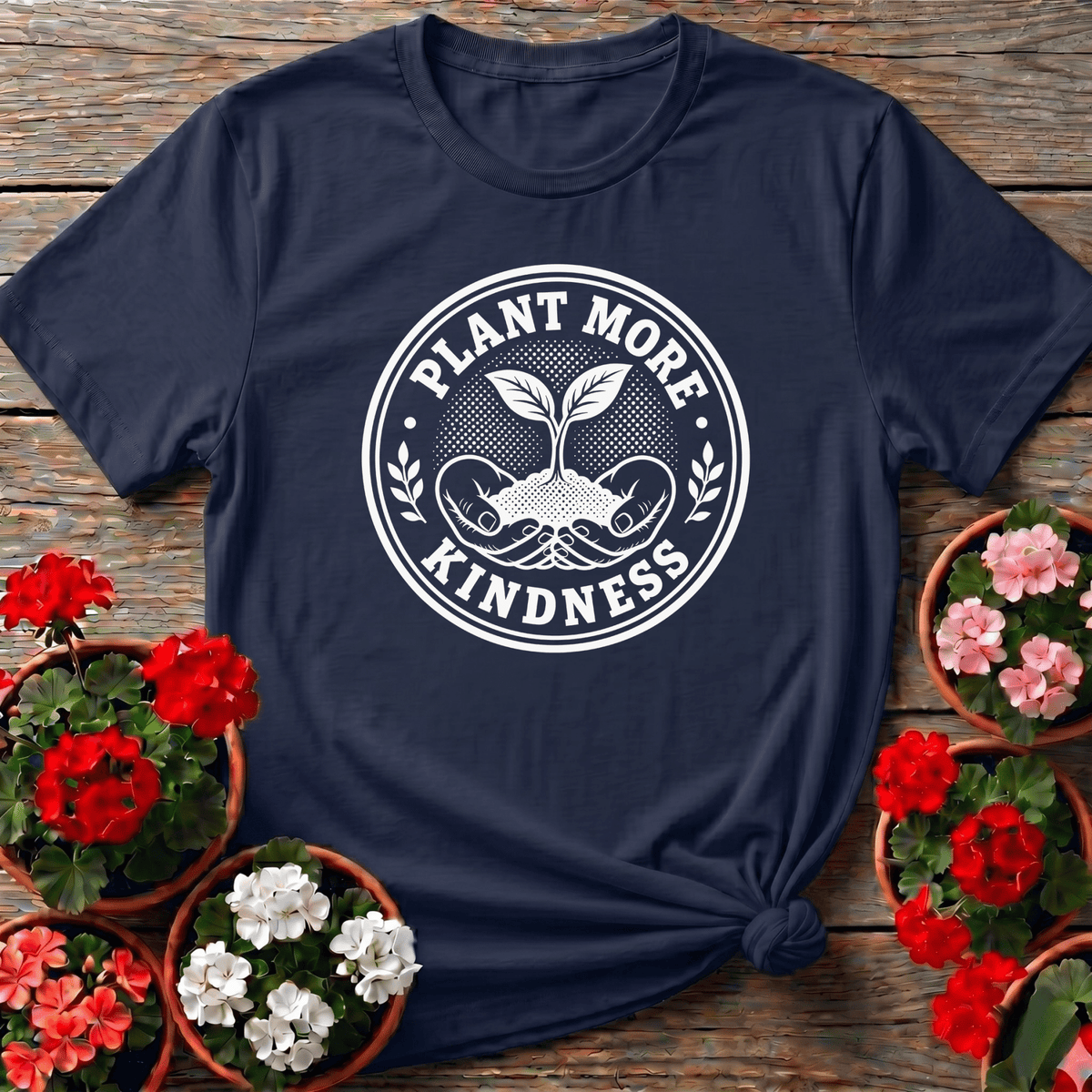 Navy cottagecore badge gardening tee with "Plant More Kindness" bold serif lettering for gardeners